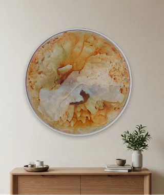 Circular amber and cream ink and resin artwork displayed above a console