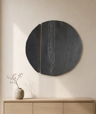 Two-part black circular resin and encaustic artwork displayed above a console